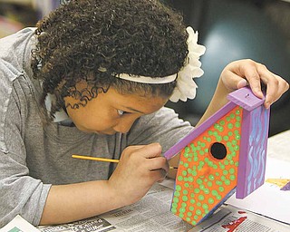 Jaylyn Graves, a student at Mollie Kessler School in Youngstown, concentrates as she paints her birdhouse. Students at the school studied homelessness. The birdhouses will go to Habitat for Humanity.