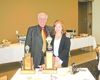 Past District Governor Bill Johnson and Susan Leetch, president of the Rotary Club of Austintown., view the awards presented to the club for its year of service at a recent District 6650 conference in Canton.