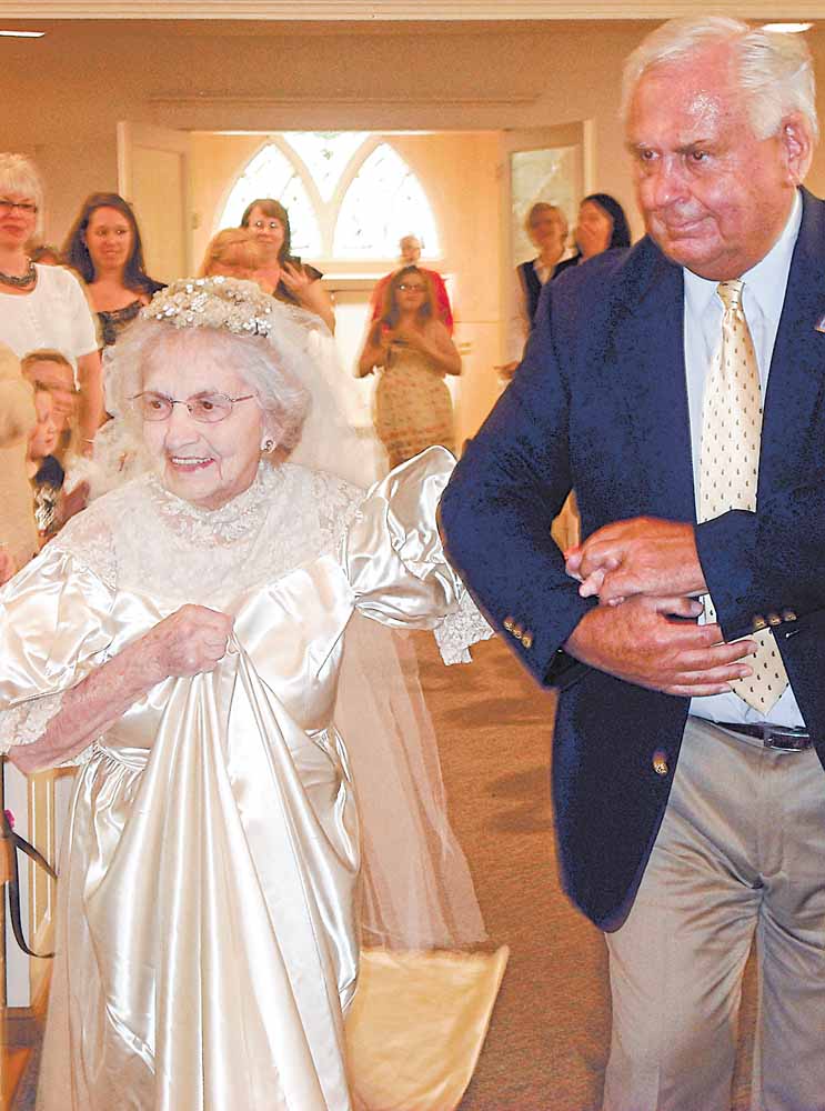 In this May 10, 2011 photo provided by Kristi Fulton, Agnes Anderson, 98, of Laketon Township is escorted by her son, Dick Anderson, down the aisle of Samuel Lutheran Church, in Muskegon, Mich., during a vintage bridal gown fashion show. Anderson wore the dress in 1938 when she married her college sweetheart, Delmar Anderson, a union that lasted more than 50 years until Delmar's death in 1989.
