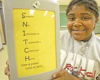 Seannille McRae, an eighth-grader at Rayen Early College Middle School in Youngstown, shows off her Destination ImagiNation team’s SNITCH box, where students can anonymously report bullying at school.