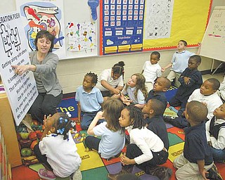 Marie Economos of Community Solutions, Warren, recites the “Cooperation Poem” with kindergarten students at Taft Elementary School, Youngstown. The kindergartners participated in Project KIND through Community Solutions, which is funded by Youngstown schools, the Raymond John Wean Foundation and the Youngstown Foundation. The program, which ran for 12 weeks at the school, focuses on good 
behavior and positive character traits.