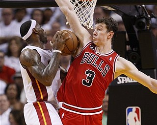 Miami Heat's LeBron James, left, goes up for a shot against Chicago Bulls' Omer Asik (3) during the second half of Game 3 of the NBA Eastern Conference finals basketball series in Miami, Sunday, May 22, 2011.