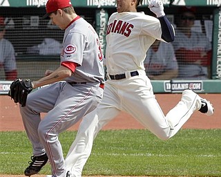 Cleveland Indians' Michael Brantley, right, is forced out at first by Cincinnati Reds starting pitcher Homer Bailey, left, after hitting a hard ground ball to Reds first baseman Joey Votto in the first inning of a baseball game in Cleveland on Saturday, May 21, 2011. 