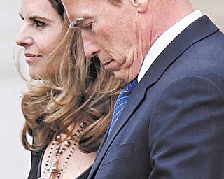 In this Jan. 22, 2011 file photo, actor and former California Governor Arnold Schwarzenegger, right, and his wife, Maria Shriver, look on during the funeral service of Maria's father, Sargent Shriver, at Our Lady of Mercy Catholic church in Potomac, Md. The power-couple's marriage has collapsed amid revelations that Schwarzenegger fathered a child with their live-in housekeeper 14 years ago but hid the truth from his wife.