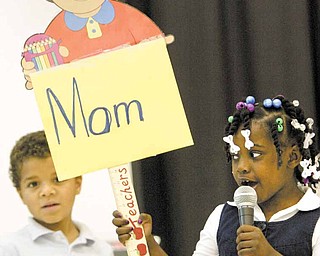 Jevonta Predergast, from left, and Ne’Ahra Page, kindergarten students at Williamson Elementary School in Youngstown, sing during a tribute to mothers Monday at the school.