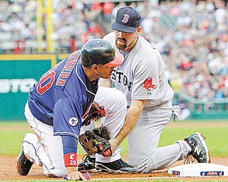 Boston Red Sox third baseman Kevin Youkilis, right, tags out Cleveland Indians' Orlando Cabrera at third base in the second inning of a baseball game Tuesday, May 24, 2011, in Cleveland. Cabrera tried to advance from first on an RBI single by Ezequiel Carrera.
