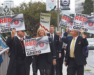 In this May 18, 2011 file photo, American Americans pilots, flight attendants and others picket outside the annual shareholders meeting of AMR Corp., parent company of the airline, outside the Hyatt Regency Century Plaza Hotel in Los Angeles. When it's time for the annual meeting and things might get ugly, there's no place like the road. 
