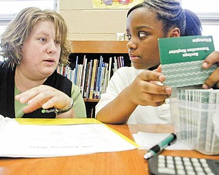 Cierra Dandridge, a fifth-grader at Taft Elementary School, and Kandie Kline, a Huntington Bank area operations specialist, prepare for the school’s twice-monthly Kids Club program. The Huntington Bank program teaches children skills in financial literacy.