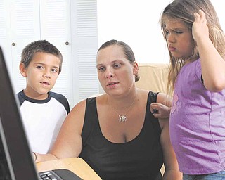 Air Force veteran Shannon Dotson shows photos of her service time to her son, Nicolae, left, and her daughter, Anastasia, at their home in Sanford, Florida, on May 12, 2011. Since getting out of the service Dotson has worked several temporary jobs while looking for full-time employment. (Joshua C. Cruey/Orlando Sentinel/MCT)