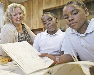 William D Lewis The Vindicator Tutor Helen Italiano works with sisters  and Naferteria, left, and Treasure Green during a tutoring session at the Rescue Mission where they live.