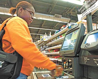 Tifany Greendge uses a self-serve checkout counter at a Wal-Mart Neighborhood grocery store in Orlando, Florida, in 2006. Wal-Mart  is taking the neighborhood grocery store concept, now called Wal-Mart Market, around the country. (Dennis Wall/Orlando Sentinel/MCT)
