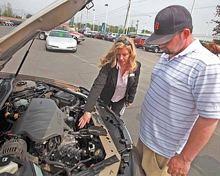 After the test drive Craig Kehoe, right, and sales person Debbie Schlegelmilch go over some details of the used car at Hank Graff Chevrolet in Davison, Michigan, on May 13, 2011. (Eric Seals/Detroit Free Press/MCT)..