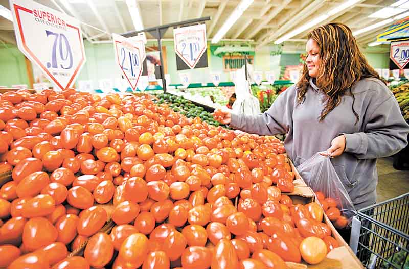 In this May 23, 2011 photo, consumer Sonia Romero shops for tomatoes at a Superior Grocers store in Los Angeles. A monthly survey shows consumers are losing faith that the economy will keep improving. (AP Photo/Damian Dovarganes)