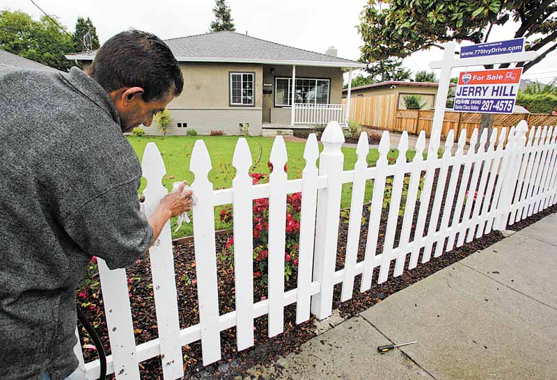 A man cleans a fence at a house for sale in East Palo Alto, Calif., Monday, May 31, 2011. Home prices fell nationwide for the eighth straight month, according to the Standard & Poor's/Case-Shiller 20-city index released Tuesday. Home prices in major areas have reached their lowest level since the U.S. housing bubble burst in 2006, stymied by foreclosures, a surplus of unsold homes and continued reluctance of Americans to buy homes. (AP Photo/Paul Sakuma)