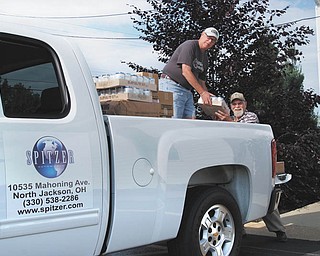 Dealership deliverance: Jim Contant, left, and Jim Lawrence, of First Federated Church of North Jackson, unload the first packages of food delivered by Spitzer Chevrolet from Second Harvest Food Bank. More than 1,000 pounds of food are off-loaded by volunteers. Spitzer Chevrolet, across the street from the church, on Mahoning Avenue, is donating the vehicle and driver twice a month to help the church feed the hungry.