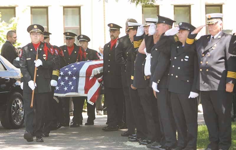 Fellow firefighters from the Mahoning Valley salute the coffin of Cardinal Joint Fire District Chief Robert Tieche as it is carried out of Canfield Methodist Church. Tieche was buried Thursday at Canfield Village Cemetery, five days after he died.