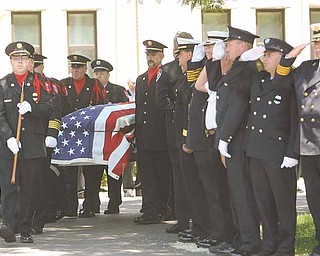 Fellow firefighters from the Mahoning Valley salute the coffin of Cardinal Joint Fire District Chief Robert Tieche as it is carried out of Canfield Methodist Church. Tieche was buried Thursday at Canfield Village Cemetery, five days after he died.