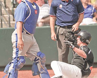 Delphos St. John catcher Austin Reindel watches as Springfield’s Brad Ferraro slides safely into home plate during their Division IV baseball semifinal Thursday in Huntington Park. The Tigers defeated the Blue Jays, 9-2, to advance to the state final Saturday against Minster.