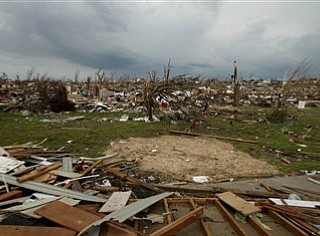 Andrea Schemet pauses while salvaging items from a destroyed home belonging to a friend's mother-in-law in Joplin, Mo. Friday, May 27, 2011. An EF-5 tornado tore through much of the city Sunday, damaging a hospital and hundreds of homes and businesses and killing at least 126 people. (AP Photo/Charlie Riedel)