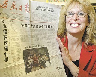 Louise Mason, principal of Girard Junior High School, holds up a Chinese newspaper with a photo and story on China Exchange Initiative, which arranges for American and Chinese educators to spend time in one another’s countries. She was on a trip to China from April 6 to 24.