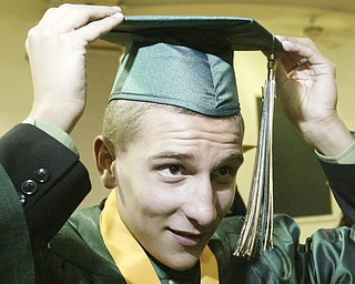 William Lewis The Vindicator Ursuline grad Daniel Gleydura checks his cap before Saturday ceremony at Stambaugh Auditorium.