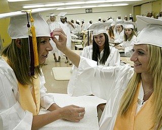 William D Lewis The Vindicator Boardman HS grad Hannah Struharik, left, gets help with her cap from Jenna Powell. Looking on is Mary Brigid Quinn. Commence was held Sunday at the HS.