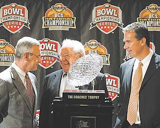 Ohio State head coach Jim Tressel, left, and Florida head coach Urban Meyer, right, are joined by former Ohio State coach Earle Bruce, center, as they stand with the BCS college football championship trophy Sunday, Jan. 7, 2007, in Scottsdale, Ariz. Florida will face Ohio State Monday in the BCS college football championship game. (AP Photo/Ted S. Warren)