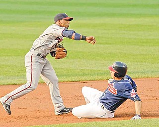 Minnesota Twins shortstop Alexi Casilla throws to first base after getting Cleveland Indians' Asdrubal Cabrera out at second base in the first inning in a baseball game, Tuesday, June 7, 2011, in Cleveland. Carlos Santana was out at first base for the double play. The Indians won 1-0. (AP Photo/Tony Dejak)