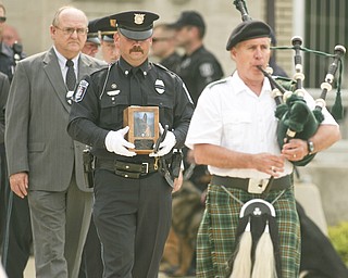 ROBERT K. YOSAY | THE VINDICATOR..New Castle PD Terry Dolquist ( CHICOS FIRST HANDLER- NOT THE HANDLER WHO IS RESPONSIBLE -)  Carries the cremains and Chico's leash to the ceremony ----Chico - New Castle Police K-9 Officer was honored today with a memorial service and  a memorial drive thru the city. Chico died Saturday after being left in a police car for almost three hours. The handler -officer- who has not been named is suspended without pay...-30-
