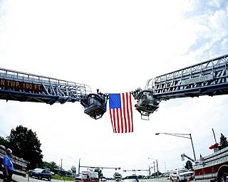 NEW CASTLE, PA - JUNE 11: Lawrence County Fire Departments drape a flag between two ladder trucks as the funeral precession of Staff Sgt. Edward Mills Jr. passed under in Shenango Township on June 11, 2011 in New Castle, PA. (photo by: Justin K. Aller)