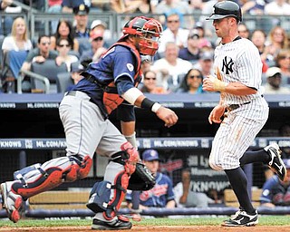 New York Yankees' Brett Gardner, right, runs past Cleveland Indians catcher Carlos Santana to score on a sacrifice fly by Curtis Granderson in the third inning of a baseball game on Sunday, June 12, 2011, in New York. (AP Photo/Kathy Kmonicek)