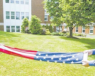 Eagle Scout candidate Greg Haylett, 16, and Barry Haylett, Greg’s father and scout master, demonstrate the proper way to fold the Stars and Stripes.