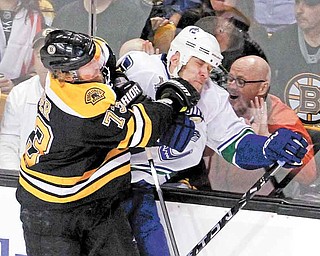Vancouver Canucks defenseman Sami Salo is checked into the boards by Boston Bruins right wing Michael Ryder during the first period of Game 6 of the NHL hockey Stanley Cup finals in Boston, Monday, June 13, 2011. (AP Photo/The Canadian Press, Jonathan Hayward)