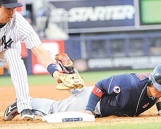 Cleveland Indians' Shin-Soo Choo, right, is safe at first on a pickoff attempt as he gets back to the bag before the tag by New York Yankees first baseman Mark Teixeira during the second inning of a baseball game Monday, June 13, 2011, at Yankee Stadium in New York. (AP Photo/Bill Kostroun)