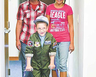 Cameron Shull, sworn in Wednesday as an honorary Air Force Reserve 2nd Lieutenant as part of the 910th Airlift Wing’s Pilot for a Day program, is shown at the 910th headquarters building at the Youngstown Air Reserve Station in Vienna with his parents, Michael Merten and Kim Shull. Cameron has cerebral palsy.