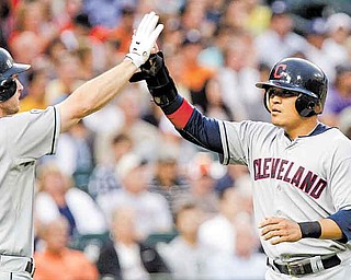 Cleveland Indians' Shin-Soo Choo, right, is congratulated at home plate by teammate Lou Marson after scoring from second base on a hit by Orlando Cabrera during the fourth inning of a baseball game against the Detroit Tigers in Detroit, Wednesday, June 15, 2011. (AP Photo/Carlos Osorio)