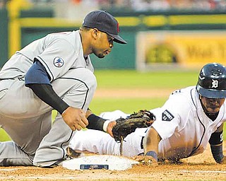 Detroit Tigers' Ramon Santiago, right, makes it safely back to first base and beats the tag from Cleveland Indians first baseman Carlos Santana during the fourth inning of a baseball game in Detroit, Wednesday, June 15, 2011. (AP Photo/Carlos Osorio)