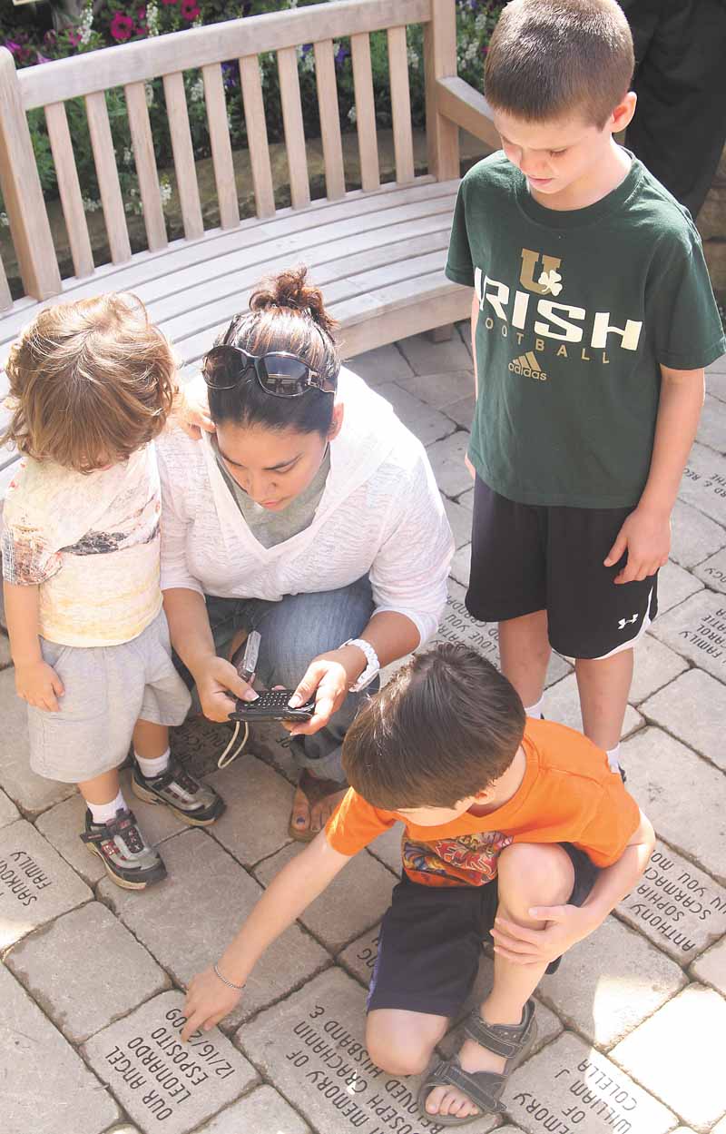  Kim Esposito of Warren, her son, Santino, 3, left and two other children, Liam Murphy, 6, kneeling, and Aidan Murphy, 8, check out donor bricks at Akron Children’s Hospital Mahoning Valley’s recently dedicated Garden of Hope in Boardman.