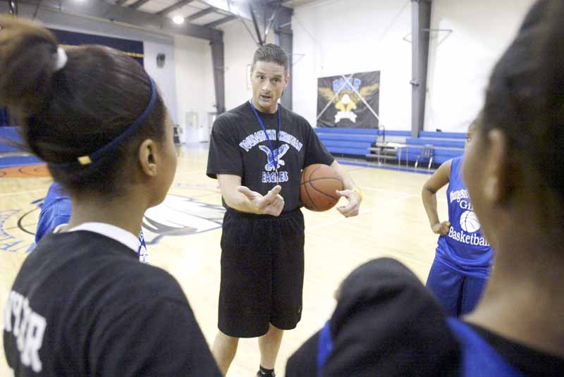 Bill Hoelzel, girls basketball coach at Youngstown Christian School, talks with his players