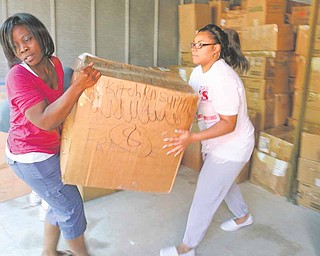 Juliana Yasnowski, left, founder of All About Children’s Needs Inc., loads a box into a container bound for Africa with help from Jessica Hancock. Boxes of donations for impoverished African children were loaded into a 40-foot container earlier this month at Uncle Bob’s Self-Storage in Hermitage. Donations are still being sought for the relief program.