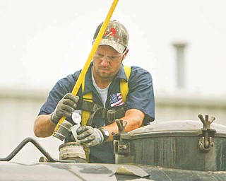Joe Allen of Patriot Water Treatment in Warren takes a sample of water from an incoming truck. The water is tested to ensure it meets environmental standards before it is treated by Patriot. Patriot officials are seeking help from state lawmakers to convince the Ohio Department of Natural Resources and the Ohio Environmental Protection Agency to allow the Warren company to continue treating wastewater.