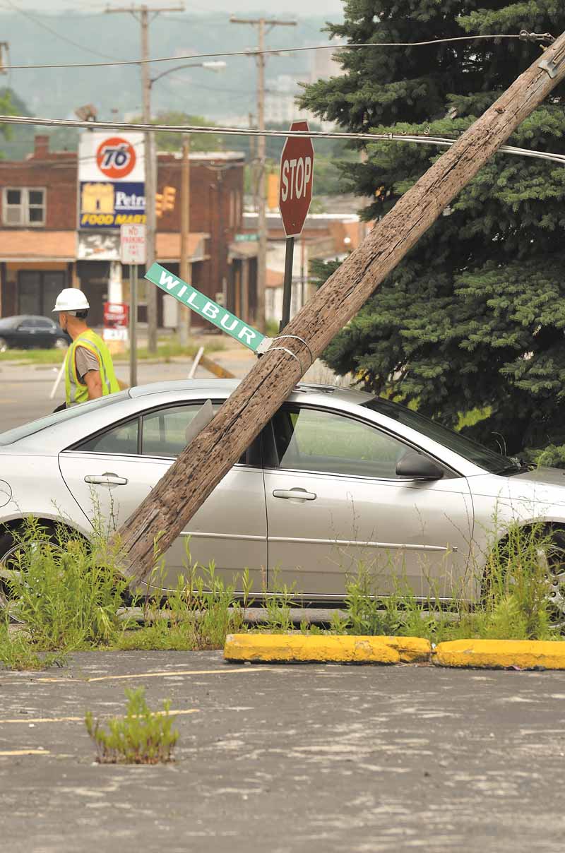 A utility pole pinned a car when a Youngstown Street Department truck brought down three utility poles after snagging onto power lines. The incident, which occurred about 10:30 a.m. Monday at Wilbur Street and South Avenue on the South Side, closed the intersection for several hours.