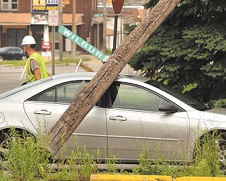 A utility pole pinned a car when a Youngstown Street Department truck brought down three utility poles after snagging onto power lines. The incident, which occurred about 10:30 a.m. Monday at Wilbur Street and South Avenue on the South Side, closed the intersection for several hours.