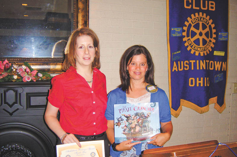 Learning about resources: Linda Titus, left, of the Ursuline Sisters HIV/AIDS Ministry, recently spoke to the Rotary Club of Austintown about services and resources offered by the Ursuline Sisters that help individuals or families dealing with HIV or AIDS. Deanna Spirko, right, incoming president of Austintown Rotary, presents a certificate for a children’s book to be donated in the Ursuline Sisters’ name to Woodside Elementary Library in Austintown.