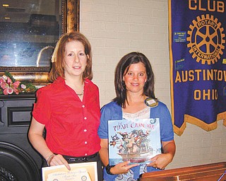 Learning about resources: Linda Titus, left, of the Ursuline Sisters HIV/AIDS Ministry, recently spoke to the Rotary Club of Austintown about services and resources offered by the Ursuline Sisters that help individuals or families dealing with HIV or AIDS. Deanna Spirko, right, incoming president of Austintown Rotary, presents a certificate for a children’s book to be donated in the Ursuline Sisters’ name to Woodside Elementary Library in Austintown.