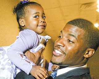 Brad Smith of the New York Jets, a graduate of Chaney High School, holds his one-year-old niece Kennedy Carpenter of Youngstown during the United Way’s “Champions Among Us” annual banquet Thursday at Mr. Anthony’s in Boardman. Smith and Ohio State junior lineman and Cardinal Mooney High School graduate John Simon spoke at the event and were honored by organizers as local champions who have represented the Mahoning Valley in a positive manner.