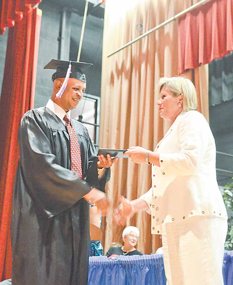 Donald Robinson, a keynote speaker at the Adult Basic and Literacy Education Program commencement ceremony, accepts his diploma from Denise Vaclav-Danko, ABLE director. The ceremony was Thursday at Chaney High School in Youngstown.