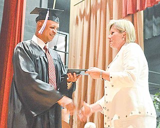 Donald Robinson, a keynote speaker at the Adult Basic and Literacy Education Program commencement ceremony, accepts his diploma from Denise Vaclav-Danko, ABLE director. The ceremony was Thursday at Chaney High School in Youngstown.