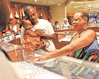 Donna Gains, right, tries on a ring with her son Dace Lumpkin (holding his niece Izzy) for her 49th birthday present at Pawn America in Burnsville, Minnesota, June 7, 2011. (Renee Jones Schneider/Minneapolis Star Tribune/MCT)