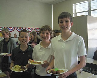 A cultural experience: Seventh-graders at Holy Family School in Poland took part in May in International Day. The event was organized by Linda Taylor, who teaches history and social studies to Grades 6-8. Students learned about a variety of cultures and traditions, then brought in food special to them. Above, Evan Leek, left, Brennan Bizon and Matthew Holsinger enjoy International Day food.